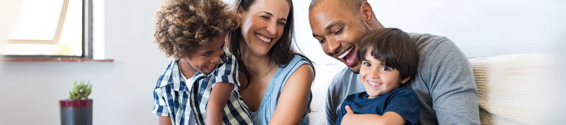 laughing family sitting together on couch