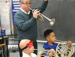 teacher and student in classroom playing musical instruments